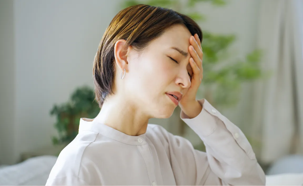 頭部を抑える女性